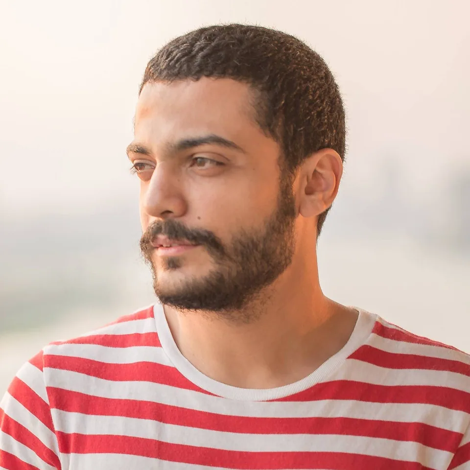 Portrait of Moataz Aboamer in a red-and-white striped T-shirt, looking off to the side
